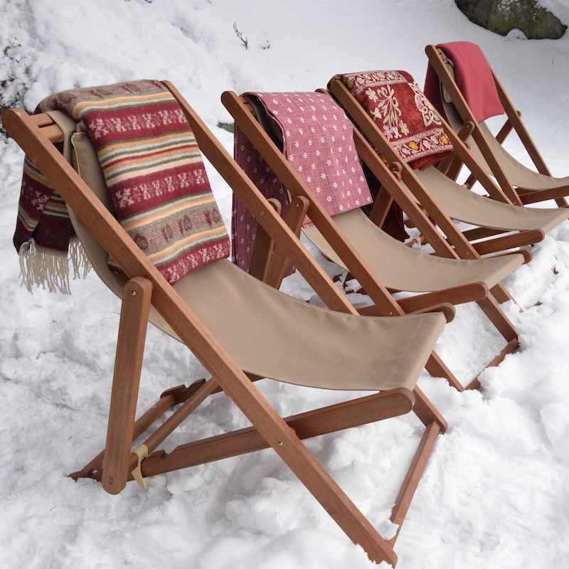 Deckchairs in the snow with blankets draped over