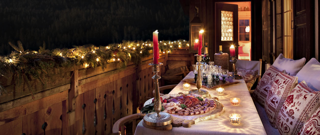 Chalet Maldeghem outdoor terrace at night - table dressed with candles and balcony with fairy lights